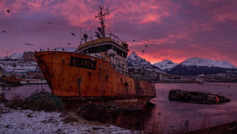 Stunning view of an abandoned ship with a beautiful sunset in Ushuaia, Argentina.